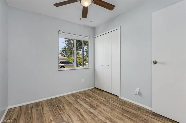 Unfurnished bedroom featuring hardwood / wood-style floors, a closet, and ceiling fan