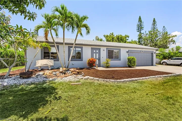 Ranch-style home with a front yard and a garage