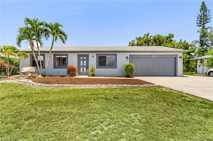 Single story home featuring a garage and a front lawn