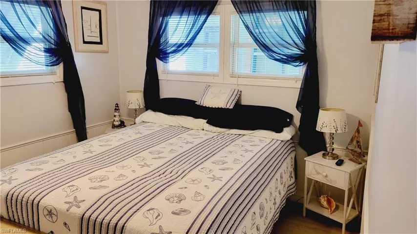 2nd Bedroom featuring wood finished floors with queen bed.