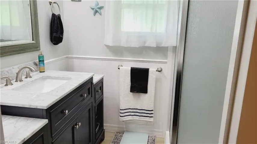 Full bath featuring vanity and a wainscoted wall