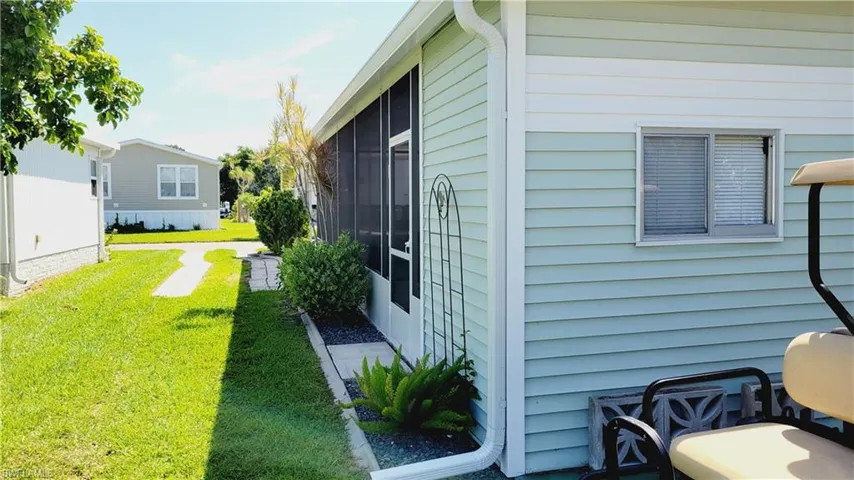 View of side of property with a lawn