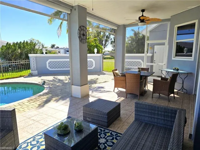 View of patio / terrace featuring a ceiling fan, a sunroom, and an outdoor living / dining area