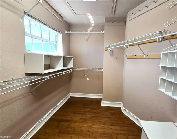 Walk in closet featuring dark wood finished floors