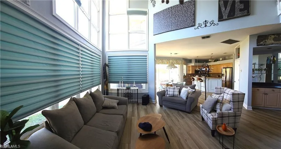 Living area featuring dark wood-style flooring and a high ceiling