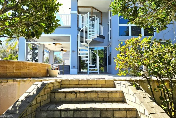 Back of property with a balcony, a patio, and a ceiling fan
