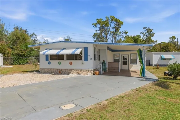 Manufactured / mobile home featuring an attached carport and concrete driveway