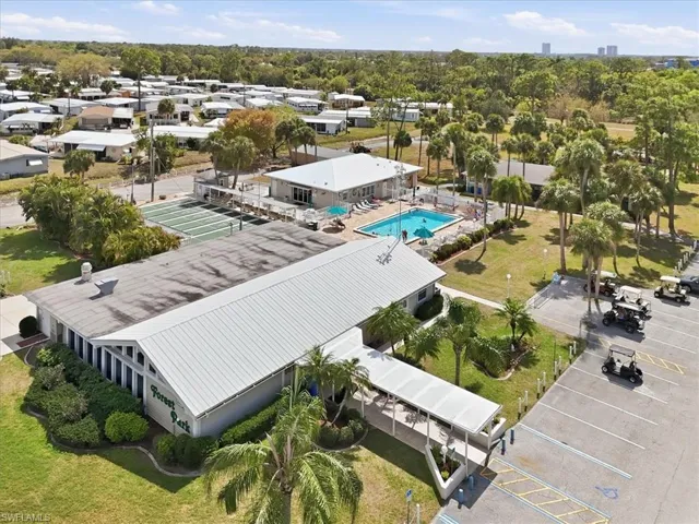 Drone / aerial view of club house and a pool