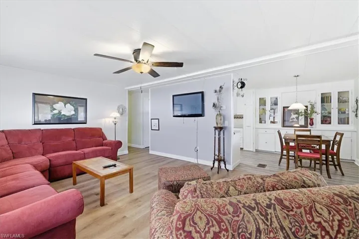 Living room with light wood-type flooring and ceiling fan