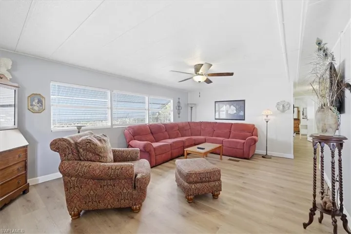 Living area with light wood finished floors and a ceiling fan