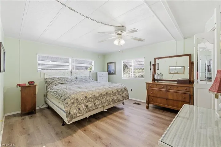 Master Bedroom with light wood-style floors, ceiling fan, and beamed ceiling