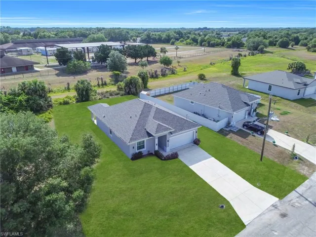 Modern single-story residence with a multi-gabled roofline, concrete driveway, attached garage, and manicured lawn