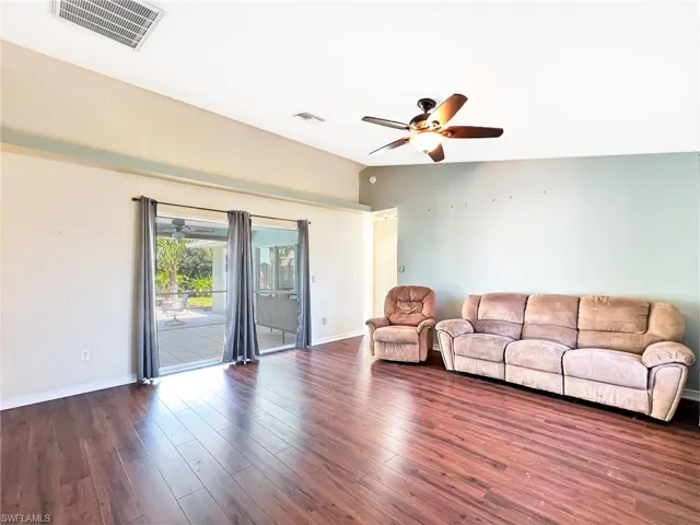 Unfurnished living room with lofted ceiling, dark wood-type flooring, and ceiling fan