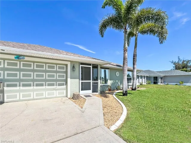 Ranch-style home featuring a garage and a front lawn