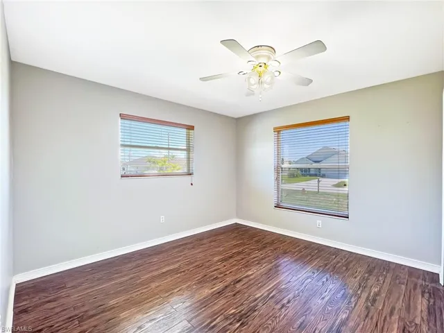 Spare room with dark hardwood / wood-style floors and ceiling fan