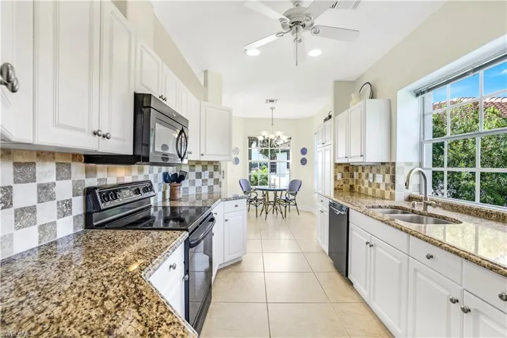 Kitchen featuring white cabinets, stove, and backsplash