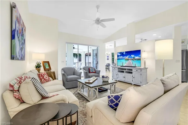 Living room featuring ceiling fan, vaulted ceiling, and tiled floors