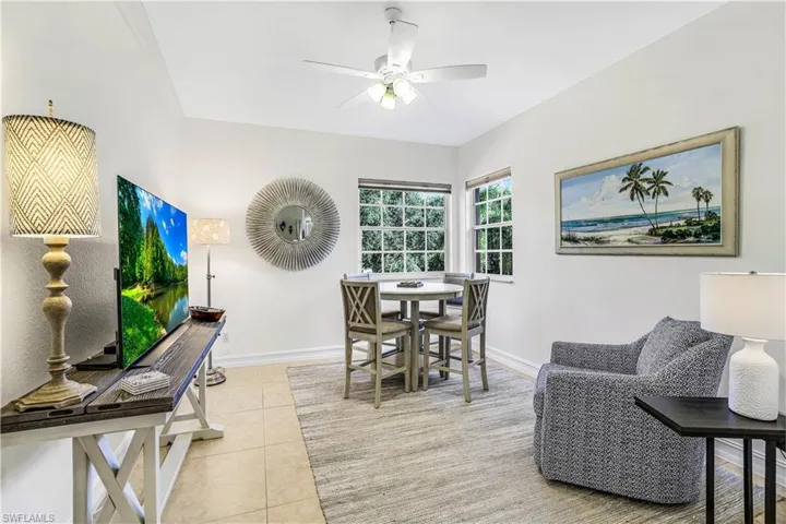 Den featuring ceiling fan and light tile patterned flooring