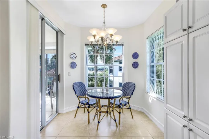 Dining area with light tile patterned floors, a chandelier, and plenty of natural light