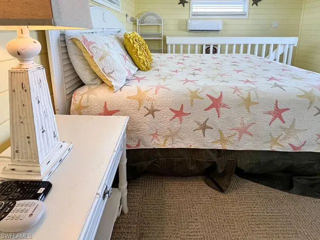 Bedroom with carpet floors and an AC wall unit