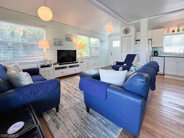 Living room featuring lofted ceiling with beams, light hardwood / wood-style floors, and a wealth of natural light