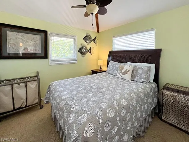 Bedroom with light colored carpet and ceiling fan