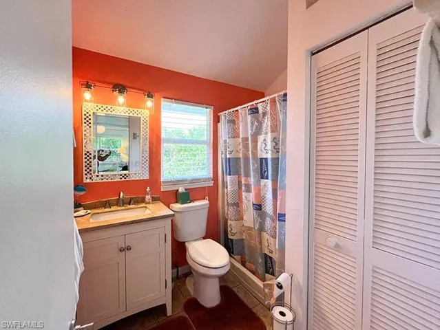 Bathroom featuring vanity, tile patterned flooring, and toilet
