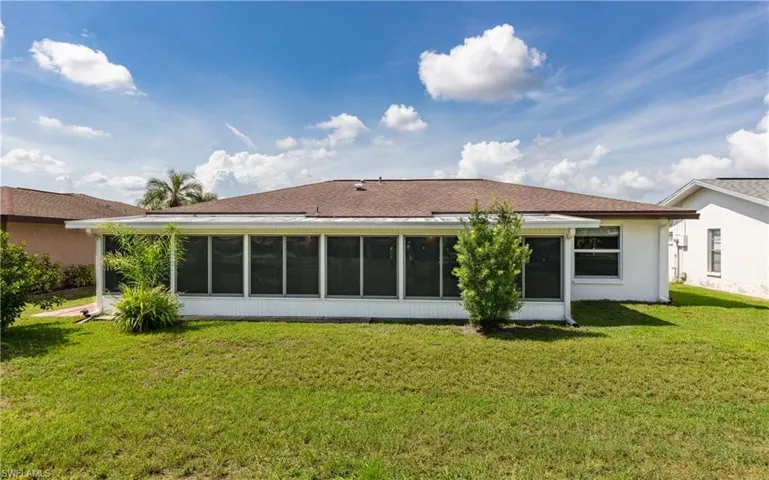 Back of property featuring a sunroom and a yard