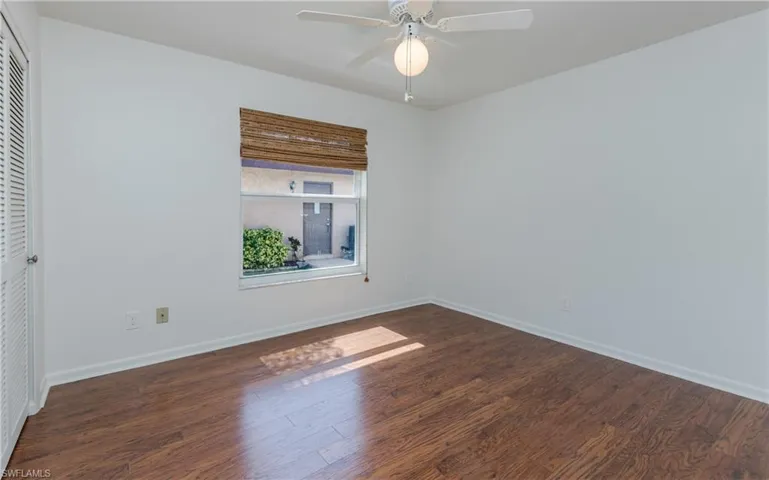 Unfurnished room with wood finished floors and a ceiling fan