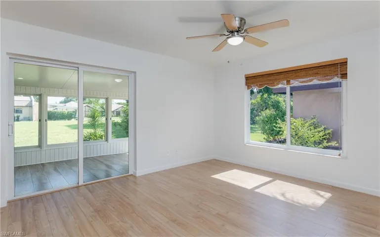 Unfurnished room featuring plenty of natural light, a ceiling fan, and wood finished floors