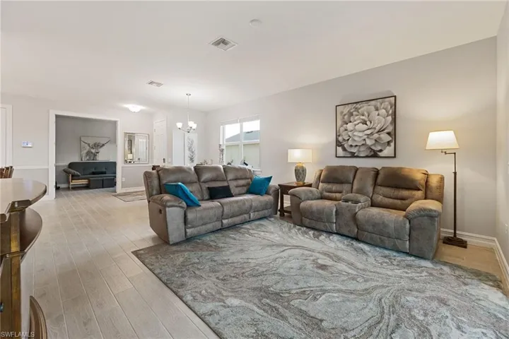 Living room with light wood-type flooring and a chandelier