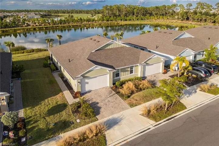 View from above of property with a nearby body of water and a tree filled landscape