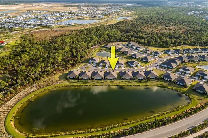 Aerial view of property and surrounding area with a large body of water and nearby suburban area