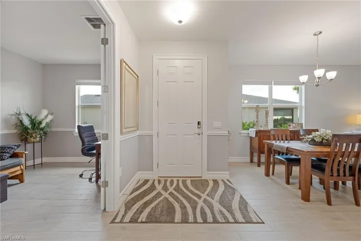Foyer entrance featuring wood finish floors and a chandelier
