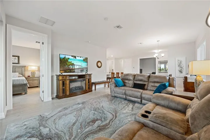 Living room with wood finish floors, a chandelier, and a fireplace