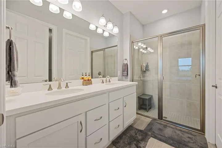 Primary Bathroom with double vanity and a stall shower