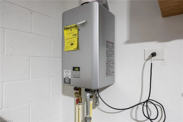 Detailed view of tankless water heater and concrete block wall