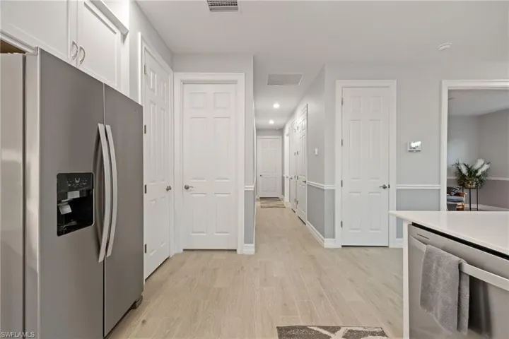 Kitchen featuring stainless steel appliances, white cabinets, light wood finished floors, and recessed lighting