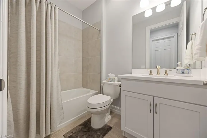 Guest Full bath with shower / tub combo, vanity, and wood tiled floors
