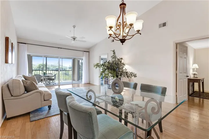 Dining area with lofted ceiling, suspended lighting, light wood finished floors, and a ceiling fan