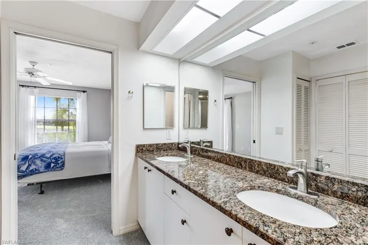 Full bathroom featuring a closet, double vanity, light colored carpet, ensuite bathroom, and ceiling fan