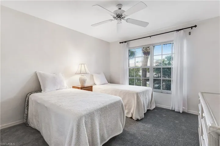 Bedroom featuring a ceiling fan and dark carpet