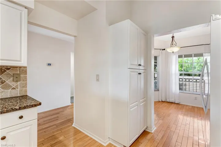 Kitchen with light wood-style flooring and white cabinetry