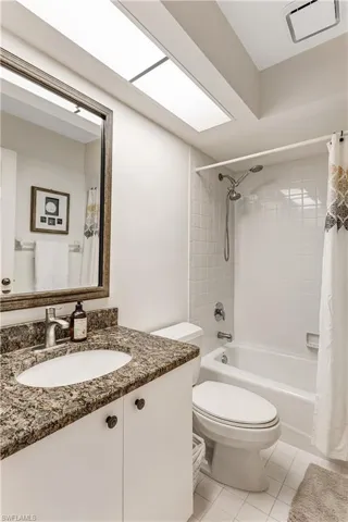 Full bathroom featuring vanity, light tile patterned floors, and shower / tub combo with curtain