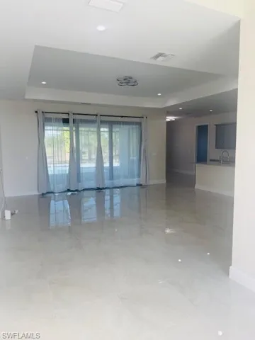 Unfurnished room with a raised ceiling and recessed lighting