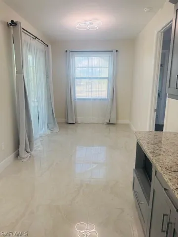 Unfurnished dining area with plenty of natural light and light marble finish floors