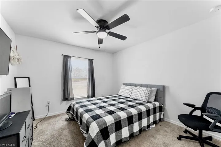 Bedroom with baseboards, a ceiling fan, and carpet flooring