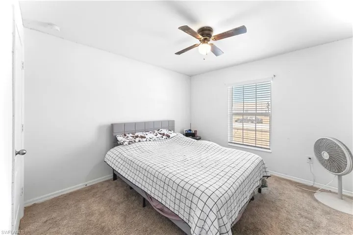 Carpeted bedroom with baseboards and ceiling fan