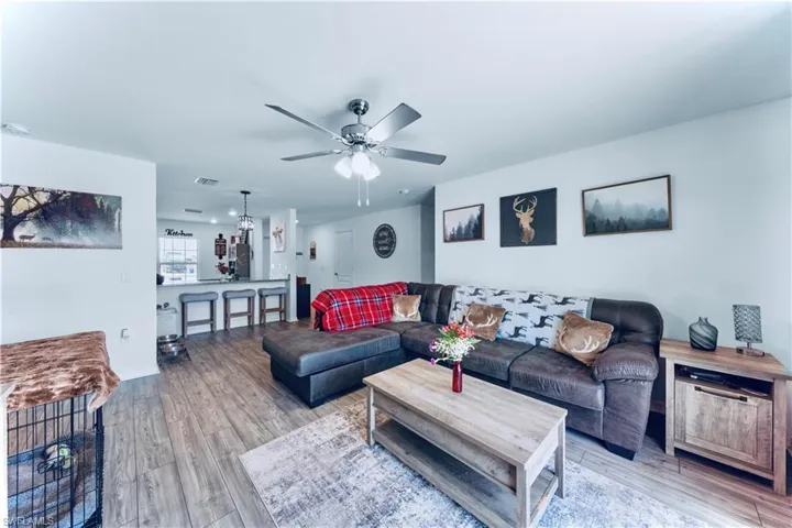 Living room featuring baseboards, ceiling fan, and wood finished floors