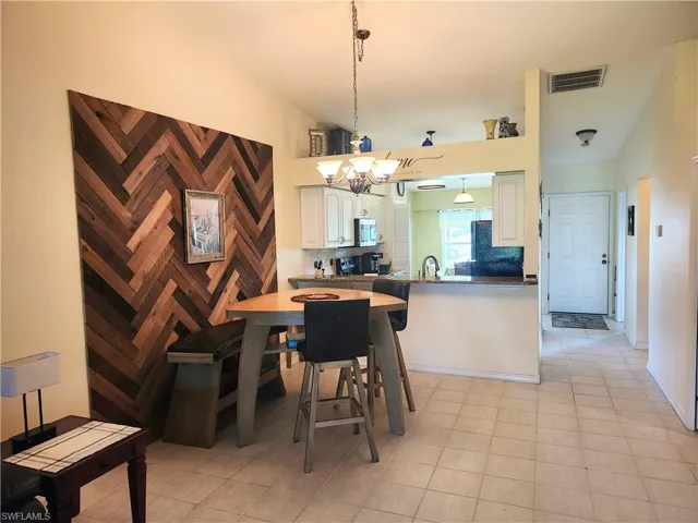 Dining area featuring light tile patterned floors and vaulted ceiling